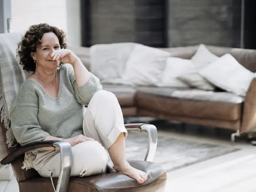 Selbstbewusste Frau im Ledersessel schaut direkt in die Kamera beim Instagram Fotoshooting mit Natalia Schuchardt