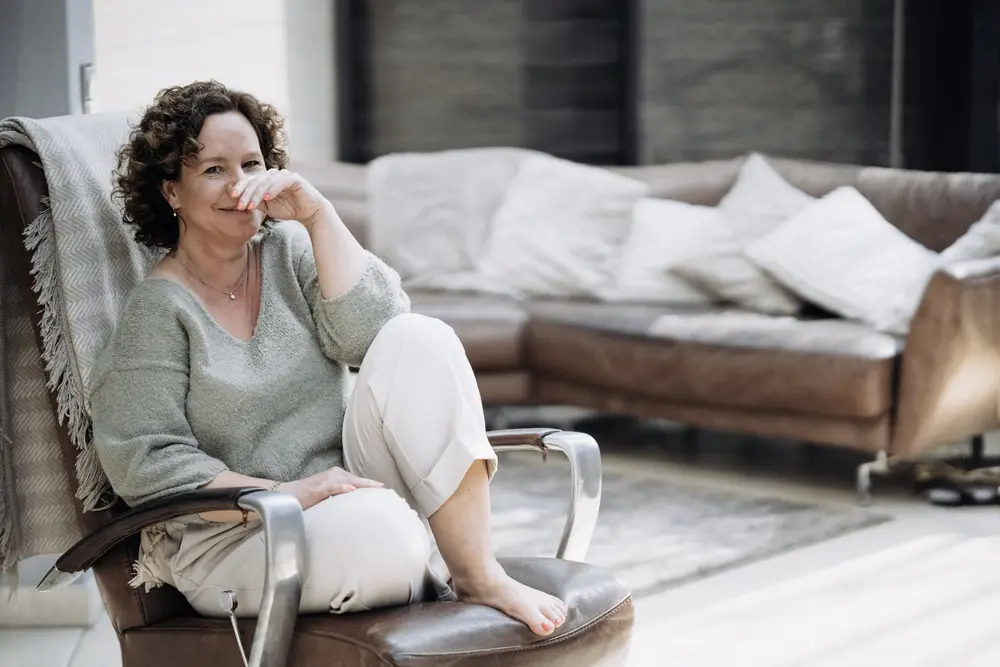 Selbstbewusste Frau im Ledersessel schaut direkt in die Kamera beim Instagram Fotoshooting mit Natalia Schuchardt